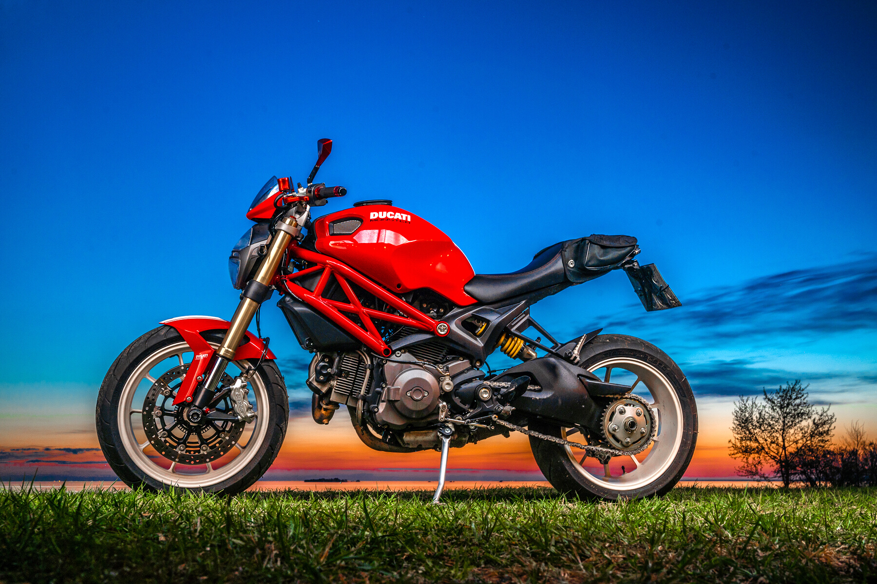 Red and Black Ducati Monster 796 on Green Grass 